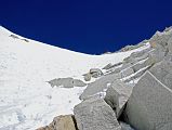 10 22 Looking Up At West Col And Descent Route From Half Way Down Finally it was my turn, but because this 200m descent down the 50-55 degree snow and rock face of the West Col is steeper and more dangerous than the East Col, I put on a harness and clipped into the fixed rope. Palde and Pemba Rinjii cut steps for me to make it easier and safer. The only real danger once again was falling rocks and ice kicked loose by the other group�s porters descending at the same time.